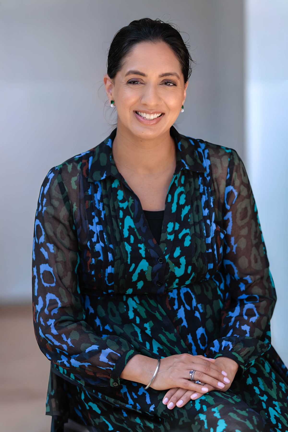 Dr Kanchan Kaur, Private GP, seated and smiling in consultation